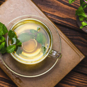 Mint tea in a teapot and cup on a wooden table