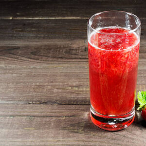 Fresh strawberry juice with berry on old wooden background. summer drink