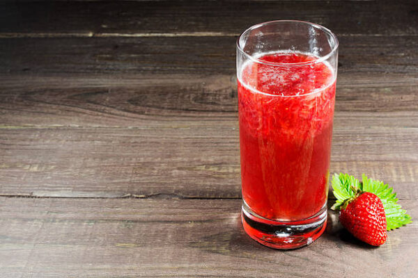 Fresh strawberry juice with berry on old wooden background. summer drink
